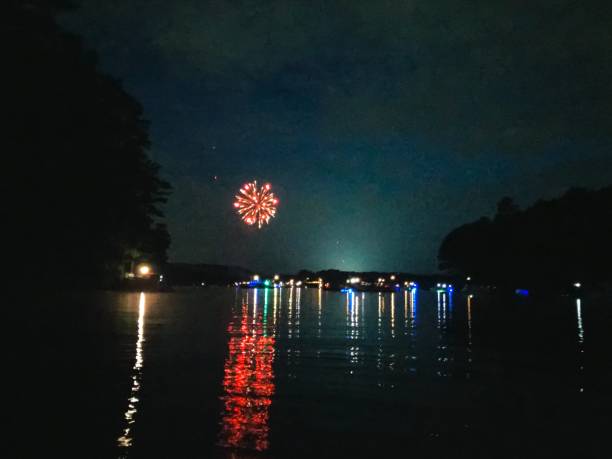 istock Fireworks With Boat Lights on Lake 1174888935