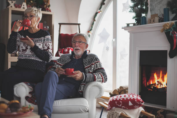 istock Senior married couple enjoying next to a fireplace 1174901544