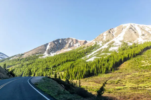 Photo of Independence Pass rocky mountain view and paved road scenic byway in morning sunrise near Aspen, Colorado in green summer