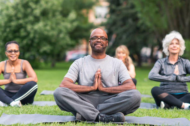 gruppo multietnico di anziani che meditano all'aperto - yoga exercising outdoors group of people foto e immagini stock