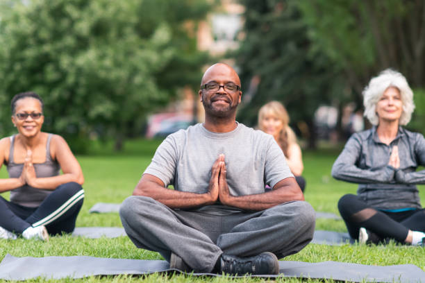 grupo multi-ethnic de séniores que meditando ao ar livre - healthy lifestyle yoga vitality flexibility - fotografias e filmes do acervo