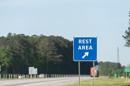Highway road in Alabama with welcome center rest area sign on street with nobody at visitor center in Lanett, Alabama