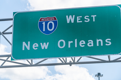 Highway road i10 west interstate 10 with direction sign and text on street for New Orleans in Lousiana with symbol