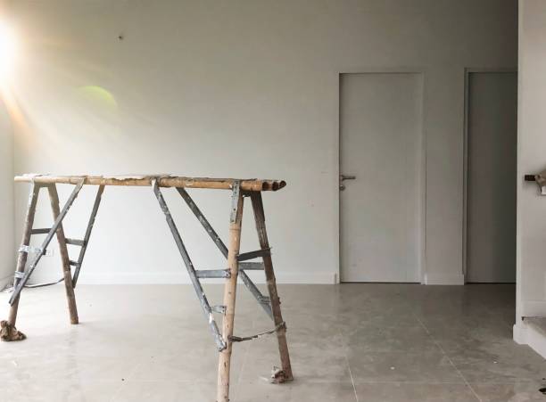 istock Interior construction of new house project with while wall background. Stairs in empty livings room and sunlight morning. Defocus 1174907210