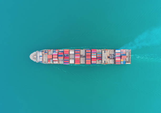 istock Aerial top view container ship on green sea for logistics, import export, shipping or transportation. 1174909163
