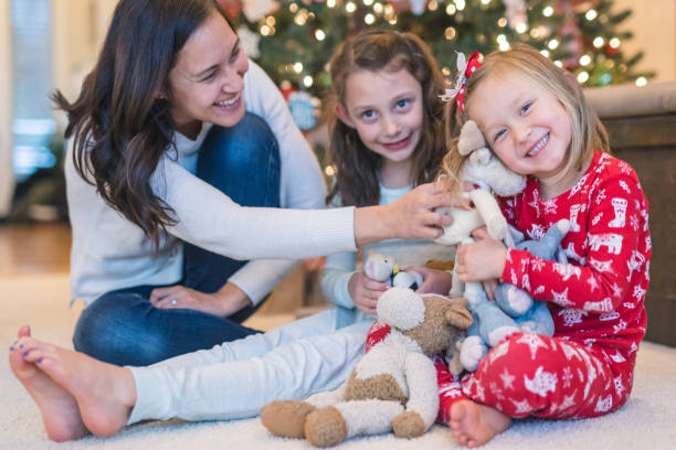istock Mom laughs with her two daughters in front of the Christmas tree 1174910368