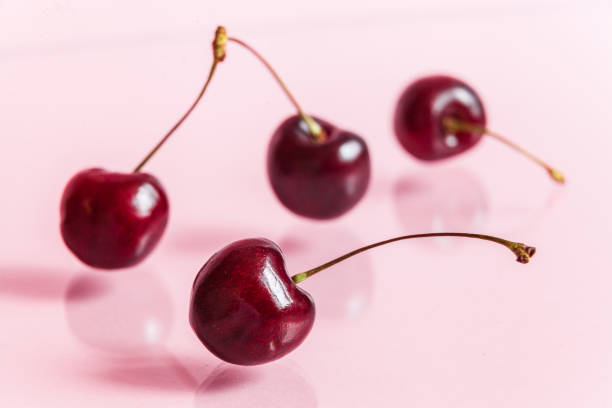 istock Four ripe fresh red cherries on a mirror background. 1174912644