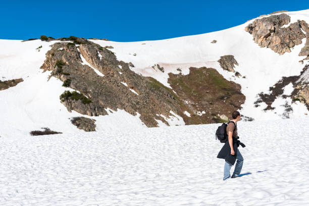 mann zu fuß auf schneebedeckten gipfel felsigen berg und blauen himmel auf linkins lake trail auf independence pass in der nähe von aspen, colorado - linkins lake trail stock-fotos und bilder