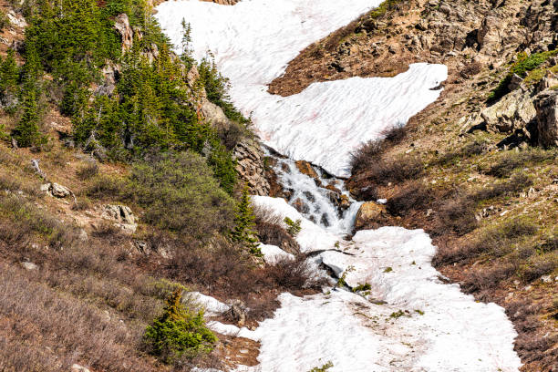 hochwinkelansicht des schneeflusses, der im sommer 2019 am linkins lake trail am independence pass in felsigen bergen in der nähe von aspen, colorado schmilzt - linkins lake trail stock-fotos und bilder