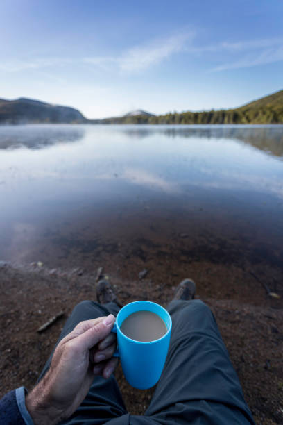 istock Man Drinking Coffee by the Lake in Camping in Autumn 1174922883