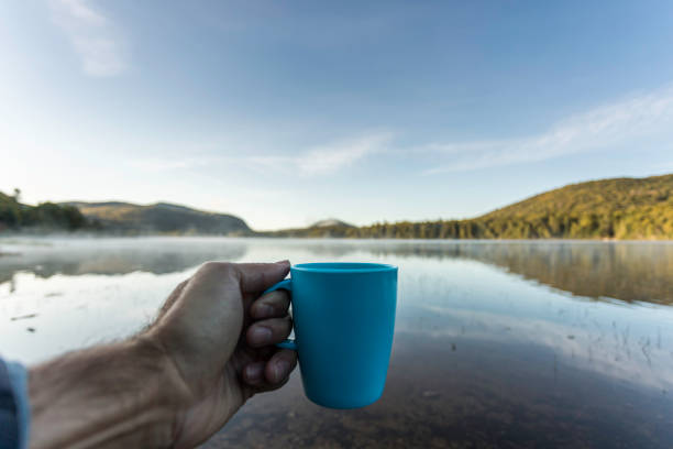 istock Man Drinking Coffee by the Lake in Camping in Autumn 1174924014