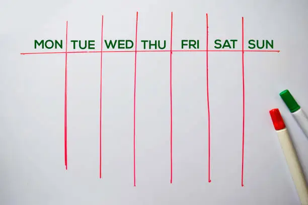 Weekly Calendar text isolated on white board background.