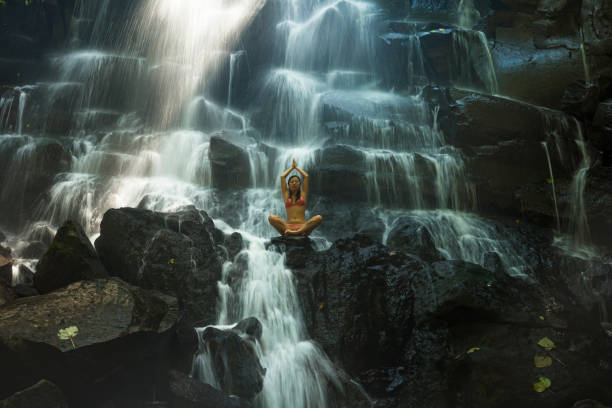 ritratto naturale di giovane bella e felice donna coreana asiatica in bikini godendosi la natura alla cascata del paradiso tropicale con sensazione magica nella destinazione di viaggio e concetto di ispirazione soul - waterfall zen like women meditating foto e immagini stock