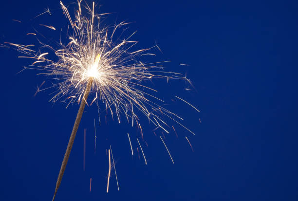 istock Burning christmas sparkler on blue background 1174927363