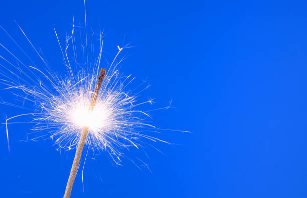 istock Burning christmas sparkler on blue background 1174927389