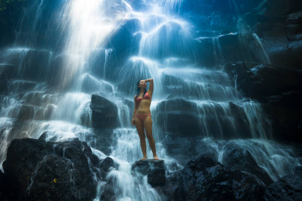 ritratto naturale di giovane bella e felice donna coreana asiatica in bikini godendosi la natura alla cascata del paradiso tropicale con sensazione magica nella destinazione di viaggio e concetto di ispirazione soul - waterfall zen like women meditating foto e immagini stock