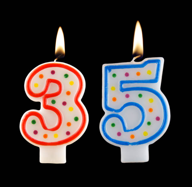 istock Burning birthday candle isolated on black, number 35 1174928532