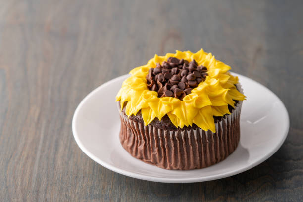 beautiful sunflower decorated chocolate cupcake on dark wood background - sunflower side view yellow flower imagens e fotografias de stock