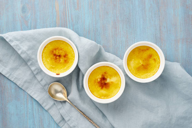 istock Crema catalana, Spanish dessert in three ramekin on blue table, copy space, top view 1174935272