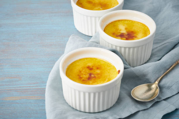 istock Crema catalana, Spanish dessert in three ramekin on blue table, copy space 1174935281