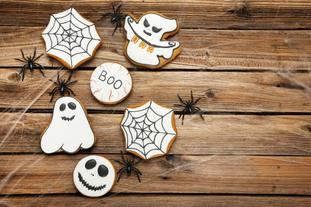 istock Halloween gingerbread cookies with spiders on brown wooden table 1174940209