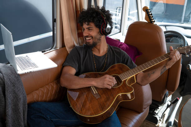 istock Ethnic nomad young man guitar player in motorhome 1174941491