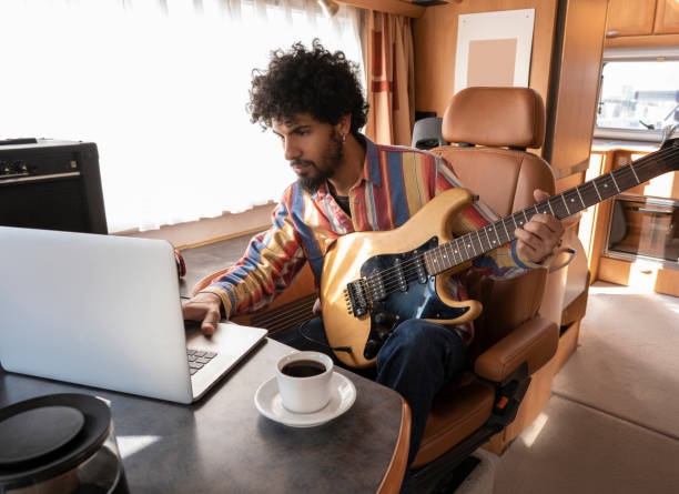 digital nomad joven guitarrista en autocaravana - mobile home audio fotografías e imágenes de stock