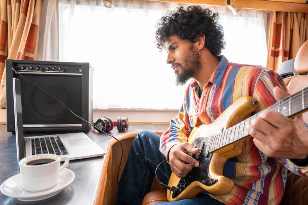istock Digital Nomad young man guitar player in motorhome 1174941538