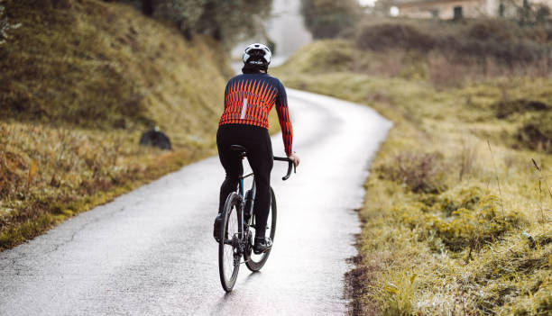 rückansicht eines radfahrers auf dem land - racing bicycle cycling professional sport bicycle stock-fotos und bilder