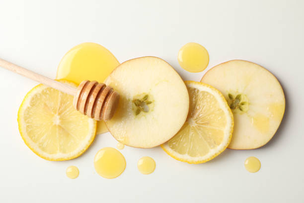 istock Dipper, honey, apple and lemon slices on white background, top view 1174942277