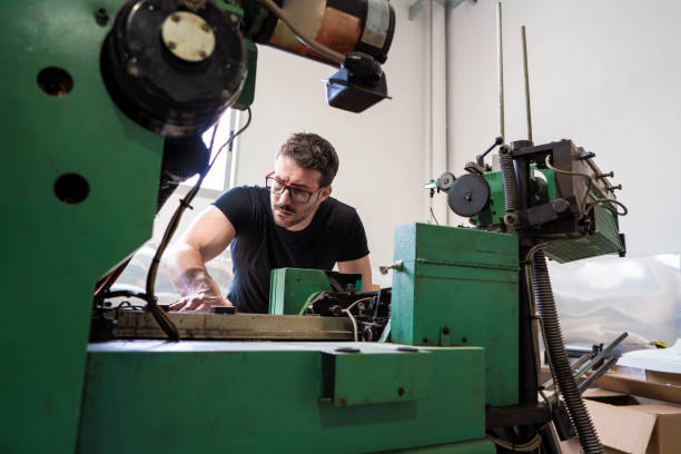 homem deslocado da impressora com a impressora de 2 cores - young men printing plant printing press factory - fotografias e filmes do acervo