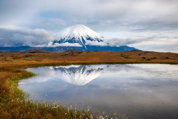 Tolbachik volcano (3.682 m) with reflection in a small lake. Tolbachik is one of the most active volcanoes on the Kamchatka Peninsula, Russia. The last massive eruption was in 2013.