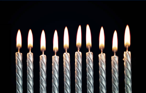 Silver burning birthday candles on black
