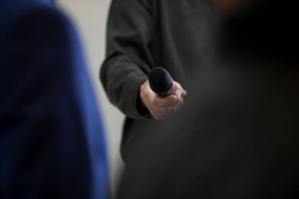 istock voice recorder phone microphone in hand, press conference 1174945291