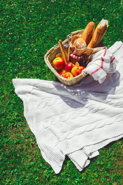 istock Hat, straw basket with food and drinks on beige plaid . 1174947717
