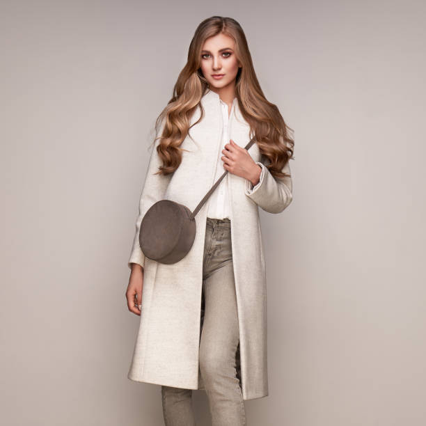 istock Young woman in white autumn coat 1174950935