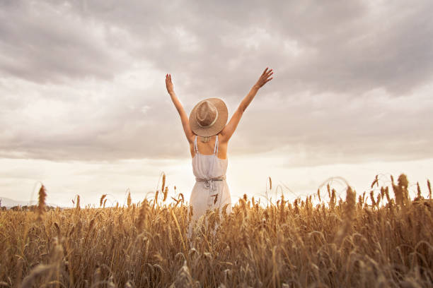 istock Girl standing in wheat field 1174952109