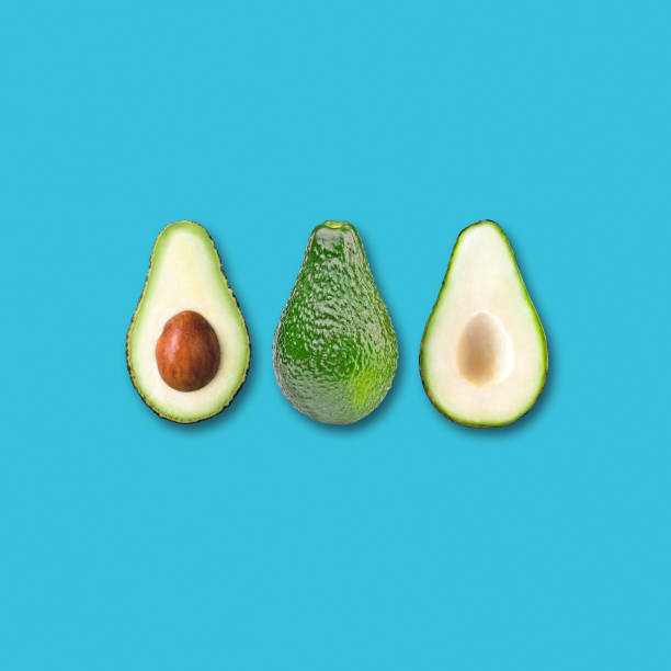 istock Avocado fruit and two halves flat lay on turquoise background 1174952271