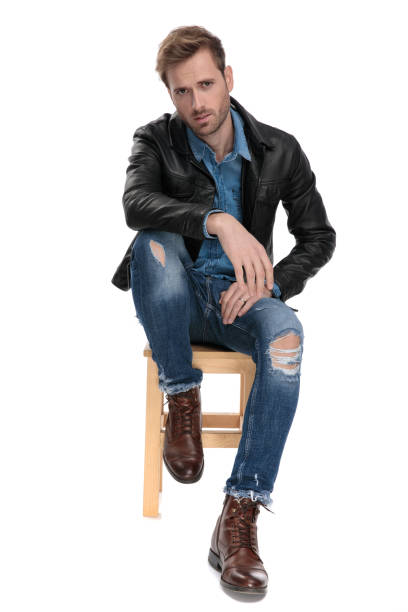 istock man sitting with leg leaning on chair 1174952336