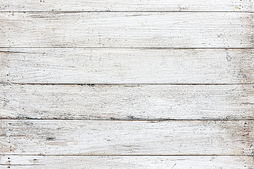 Very old blank, textured white wooden timber board background with lots of cracks and scratches that shows grunge effects, great backdrop for copy space.