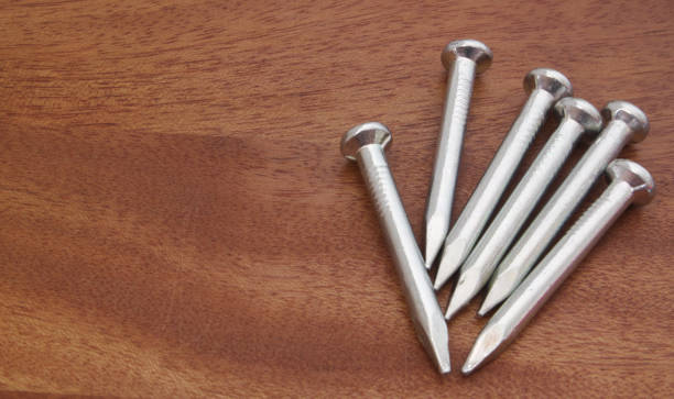istock Metallic nails on wooden table 1174952405