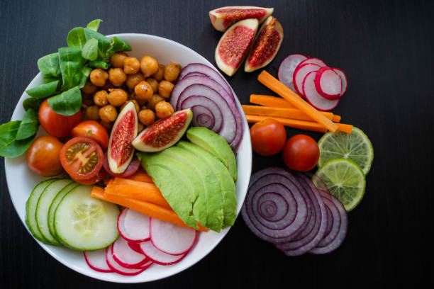istock Buddha bowl with avocado, cucumber and figs on background covered with vegetables. 1174952436