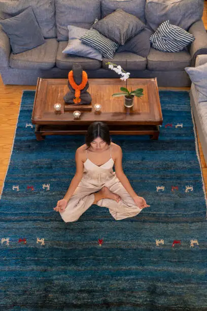 Asian woman yoga exercise in blue carpet aerial view