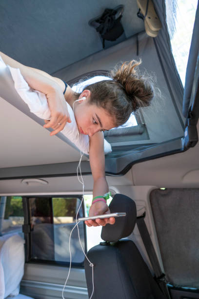 adolescente chica en furgoneta camper escuchando música - mobile home audio fotografías e imágenes de stock