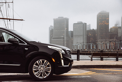 Brooklyn, New York, USA - May 3, 2019: Front view of a 2018 Cadillac XT5 parked in Brooklyn Heights in the city of New York City . XT5 is the new suv by Cadillac, one of the most famous automotive brand in United States. Foggy day with the Manhattan skyline in the background.
