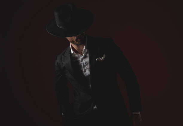 istock mysterious young man in tuxedo looking to side on black background 1174964157