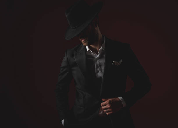 istock mysterious young man in tuxedo looking to side on black background 1174964666