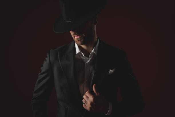 istock attractive man wearing tuxedo and hat fixing collar 1174965216