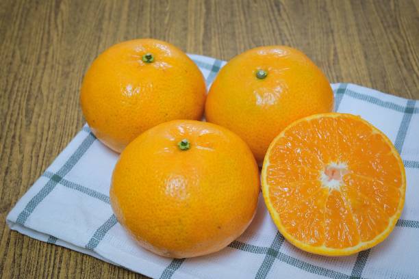 naranjas maduras y dulces sobre una mesa de madera - zumo 660 fotografías e imágenes de stock