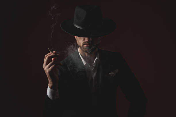 istock enigmatic young man smoking on black background 1174965884